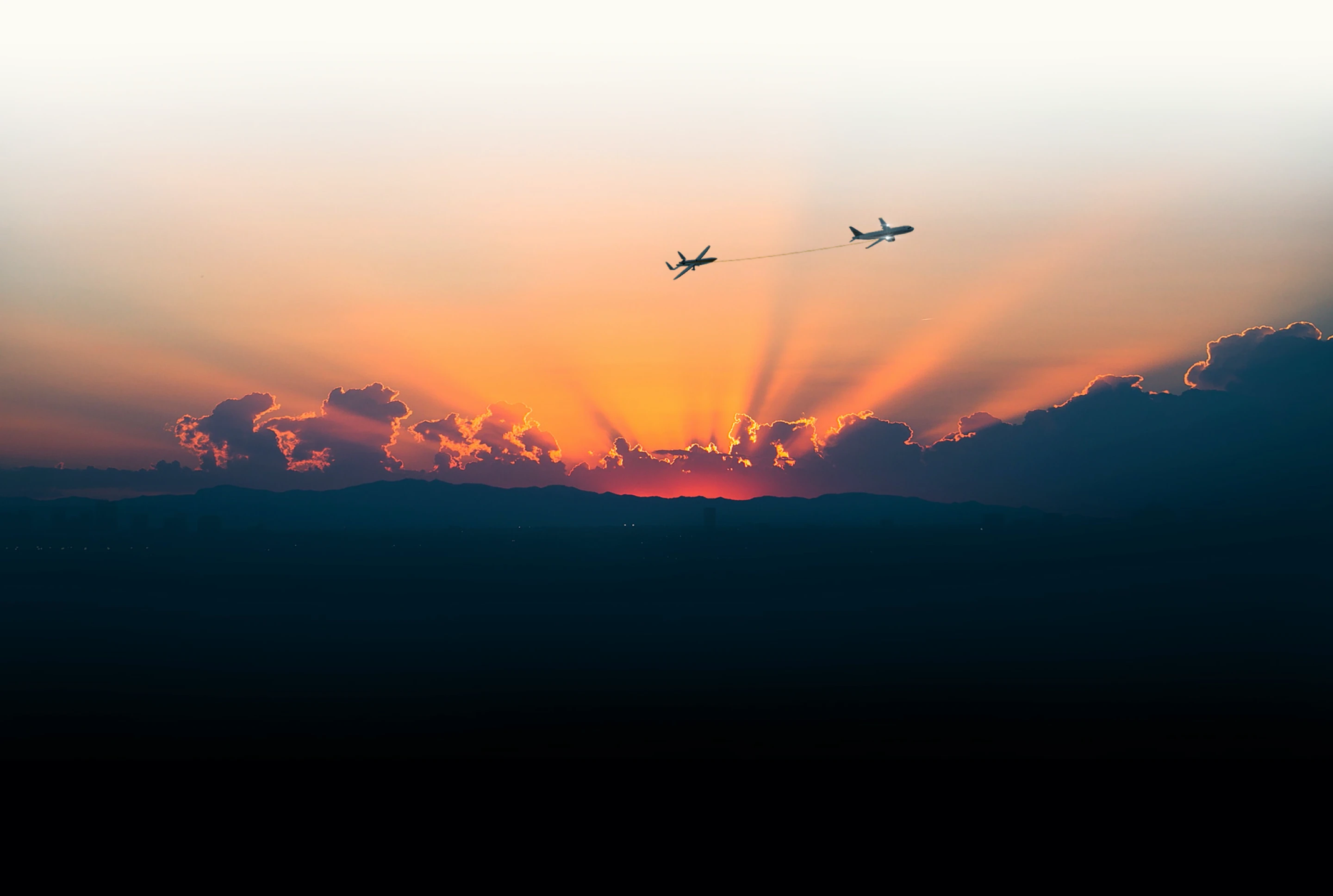 A business-jet aircraft towing the Fenix glider at sunset